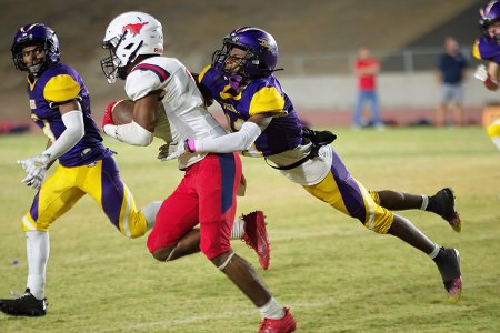 Lemoore's Kiontre Harris makes a leaping tackle against Hanford.